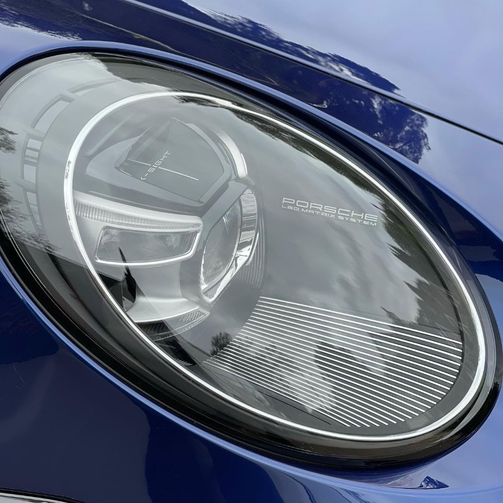McLaren 600LT Spider in blue with doors up — dramatic low angle