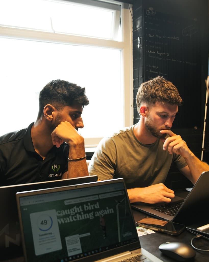 Joe and Jacob working together at laptops — planning and strategy