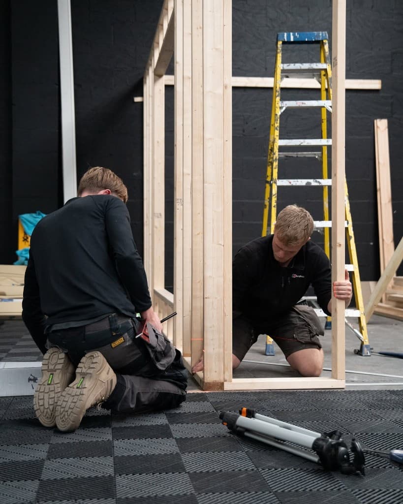 Team building the JnJ Detailing studio interior — hands-on construction work